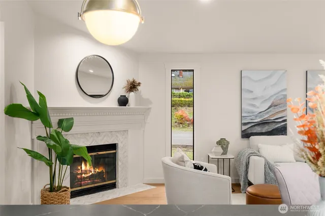 a living room with furniture a fireplace and a dining table with wooden floor