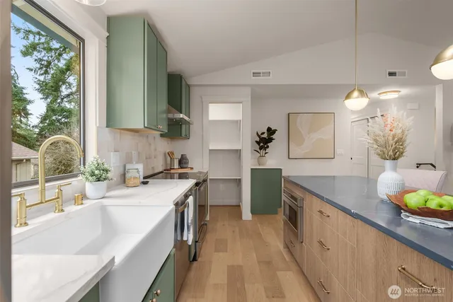 a kitchen with a sink a counter top space and living room view