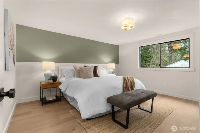 a bedroom with a bed and a painting on the wall