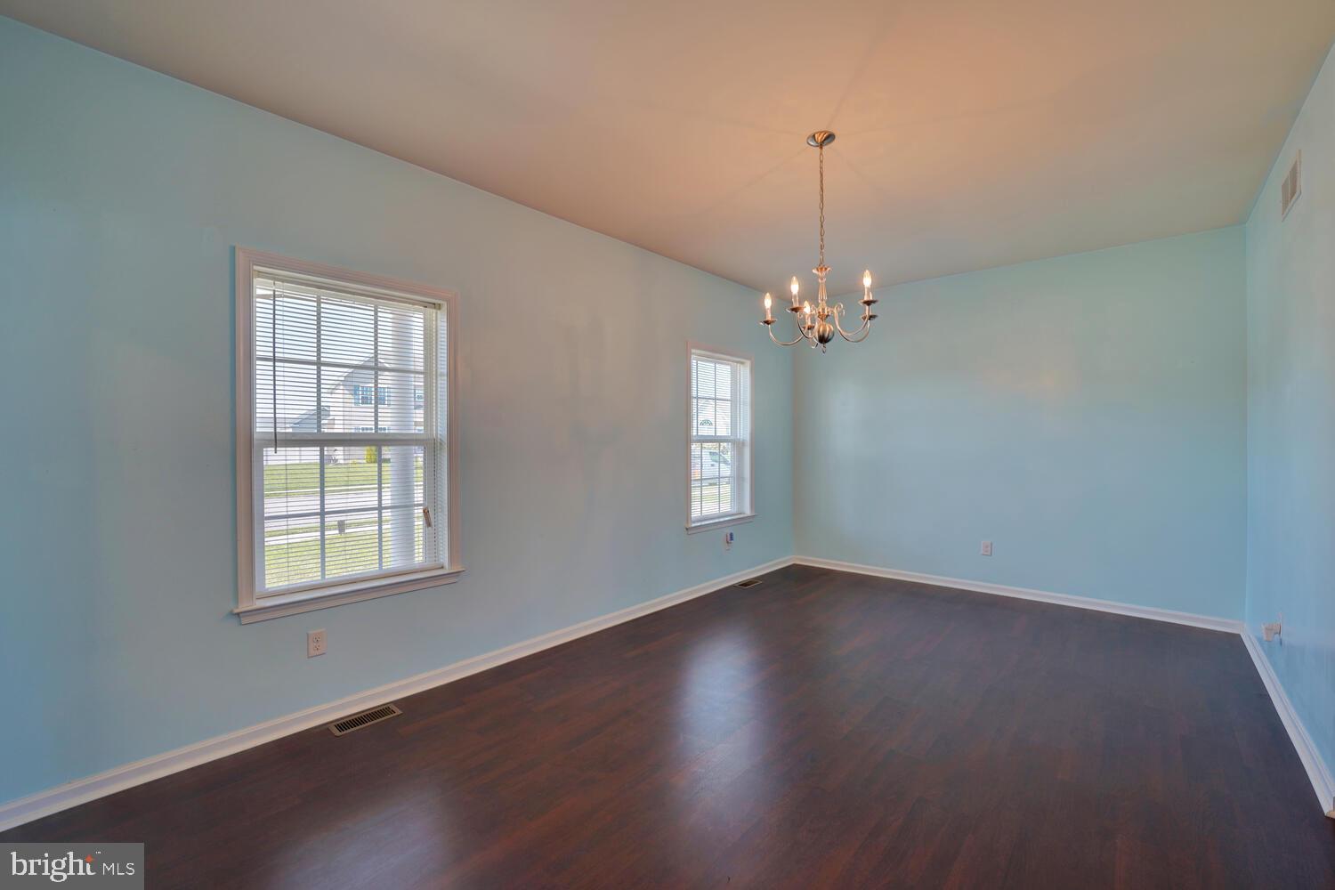 167 Spring Dale Lane Felton, DE 19943 - Photo 12 of 54 an empty room with wooden floor chandelier and windows