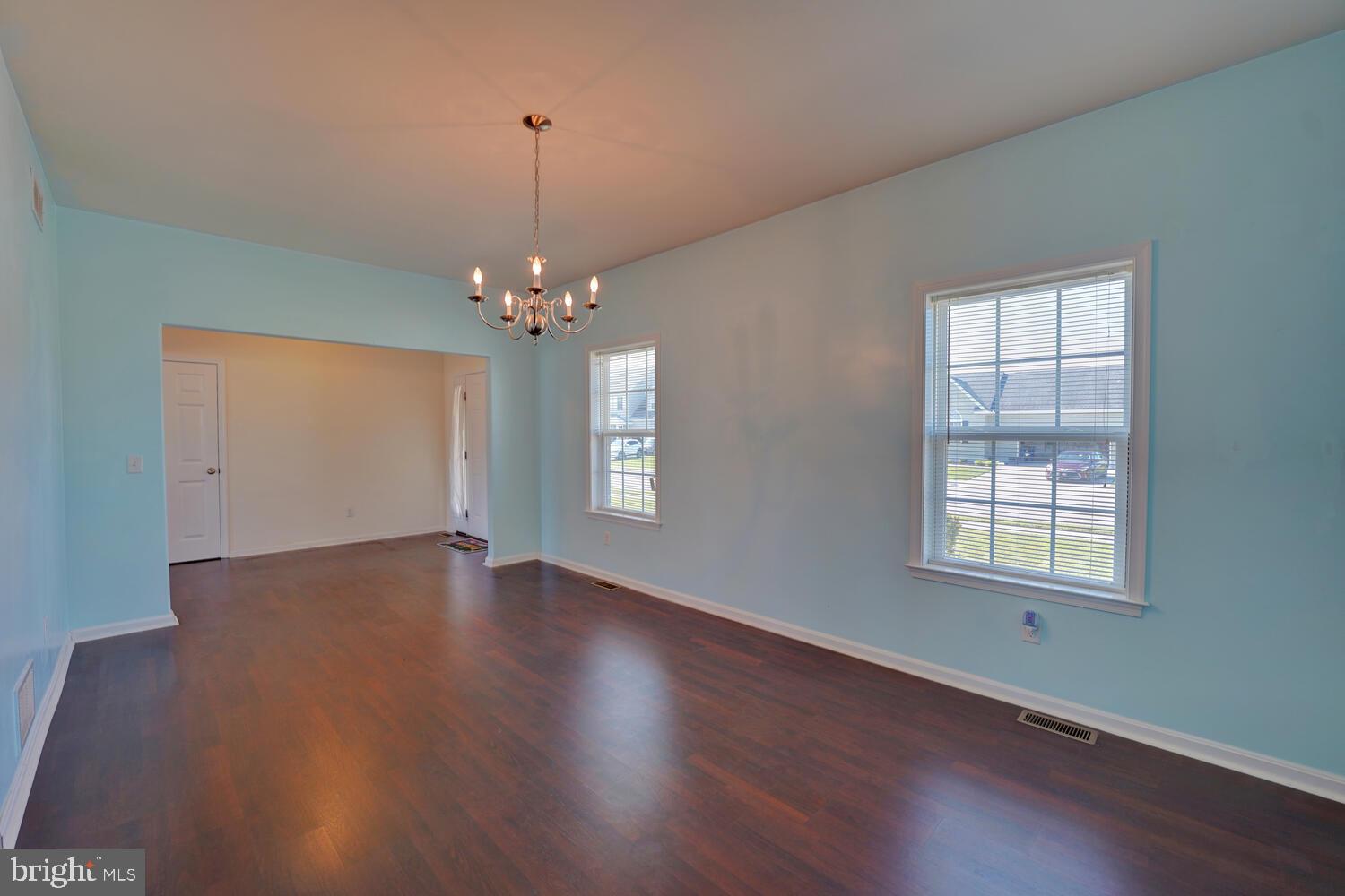 167 Spring Dale Lane Felton, DE 19943 - Photo 13 of 54 an empty room with wooden floor chandelier and windows
