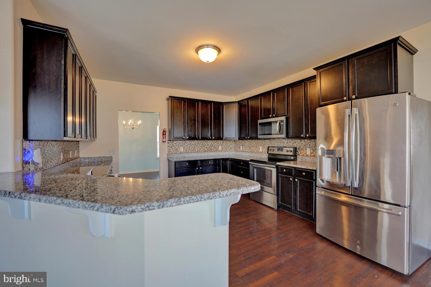 167 Spring Dale Lane Felton, DE 19943 - Photo 21 of 54 a kitchen with stainless steel appliances granite countertop a refrigerator a stove a sink a microwave and a refrigerator