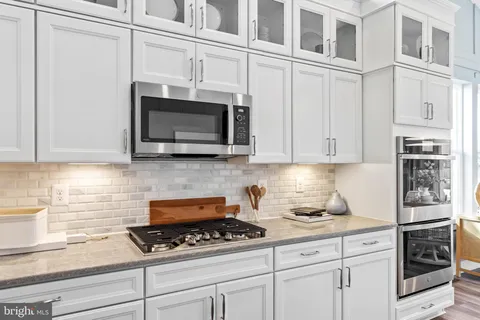 a kitchen with stainless steel appliances granite countertop a refrigerator a stove and a sink with wooden cabinets