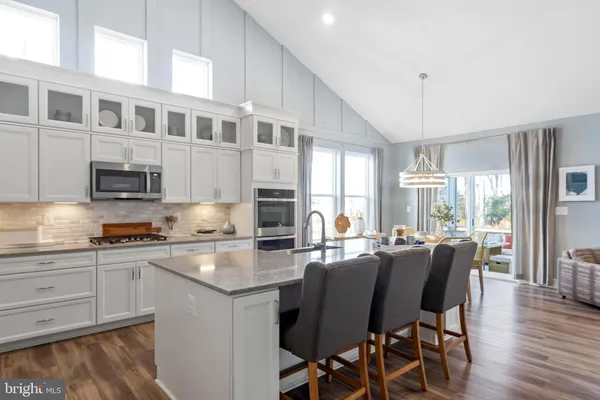 a kitchen with stainless steel appliances granite countertop a stove a refrigerator a table and chairs