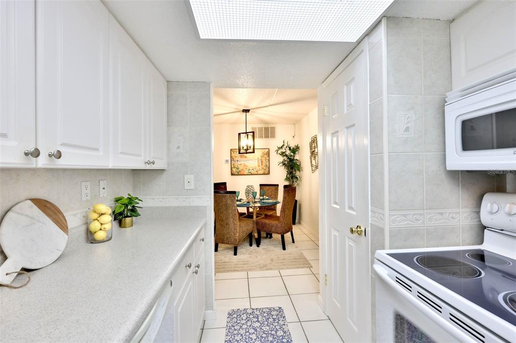 8901 Blind Pass Road, Unit 224 St. Pete Beach, FL 33706 - Photo 11 of 46 a kitchen with stainless steel appliances granite countertop a sink and cabinets