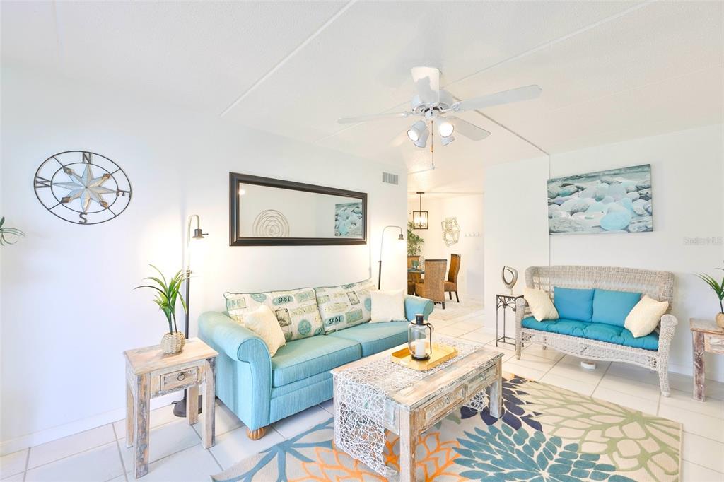 8901 Blind Pass Road, Unit 224 St. Pete Beach, FL 33706 - Photo 12 of 46 a living room with furniture a rug and a wall painting
