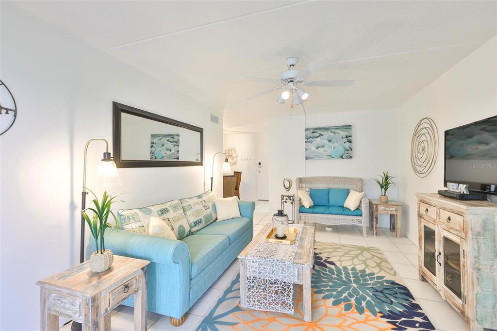 8901 Blind Pass Road, Unit 224 St. Pete Beach, FL 33706 - Photo 13 of 46 a living room with furniture and a flat screen tv