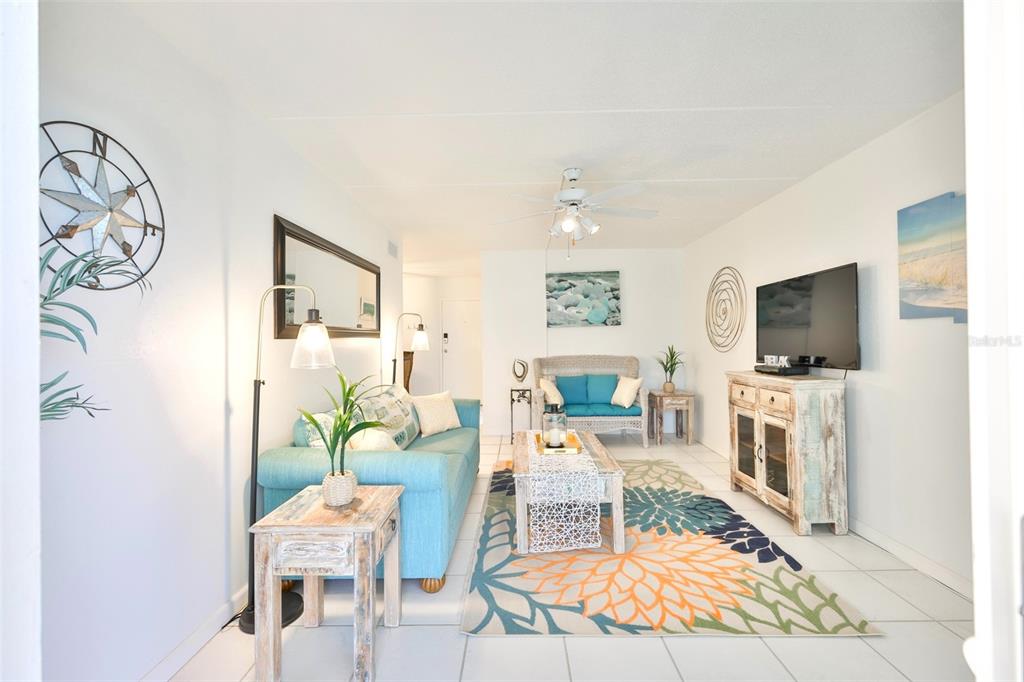 8901 Blind Pass Road, Unit 224 St. Pete Beach, FL 33706 - Photo 14 of 46 a living room with furniture a flat screen tv and a fireplace