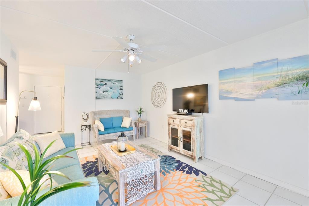 8901 Blind Pass Road, Unit 224 St. Pete Beach, FL 33706 - Photo 15 of 46 a living room with furniture and a flat screen tv