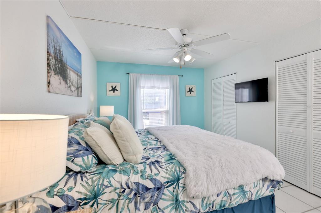 8901 Blind Pass Road, Unit 224 St. Pete Beach, FL 33706 - Photo 22 of 46 a bedroom with a bed and a flat screen tv