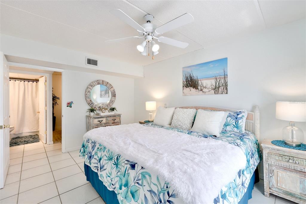 8901 Blind Pass Road, Unit 224 St. Pete Beach, FL 33706 - Photo 23 of 46 a bedroom with a large bed and a chandelier