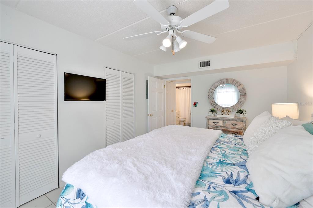 8901 Blind Pass Road, Unit 224 St. Pete Beach, FL 33706 - Photo 24 of 46 a bedroom with a bed and a chandelier