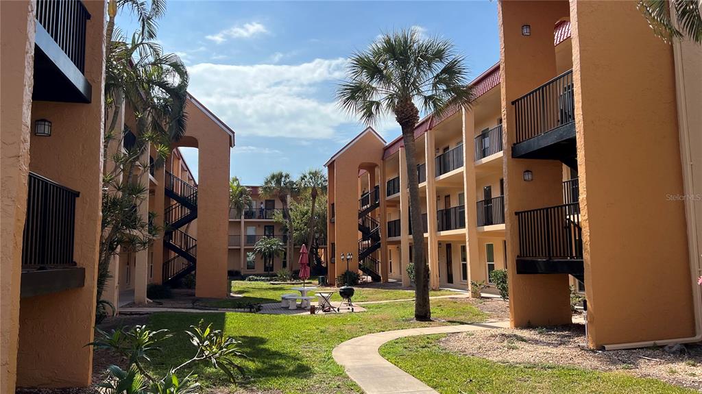 8901 Blind Pass Road, Unit 224 St. Pete Beach, FL 33706 - Photo 41 of 46 a front view of multi story residential apartment building with yard