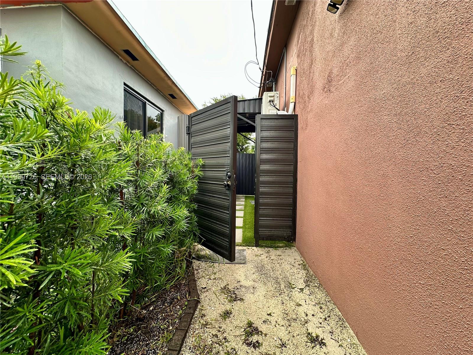 1309 Northwest 55th Terrace, Unit STUDIO Miami, FL 33142 - Photo 16 of 18 a backyard of a house with wooden fence