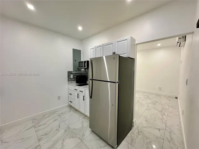 a white refrigerator freezer and a stove sitting inside of a kitchen