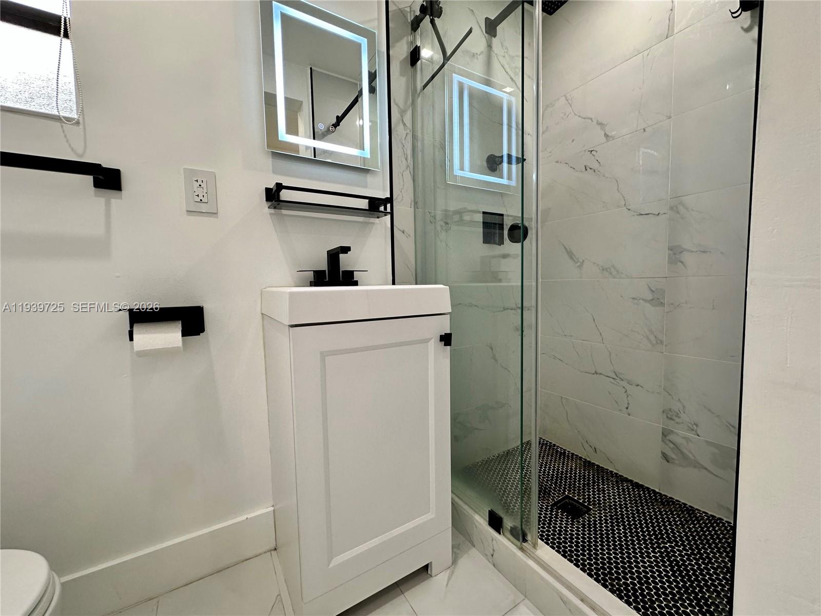 1309 Northwest 55th Terrace, Unit STUDIO Miami, FL 33142 - Photo 5 of 18 a bathroom with a sink a toilet and shower