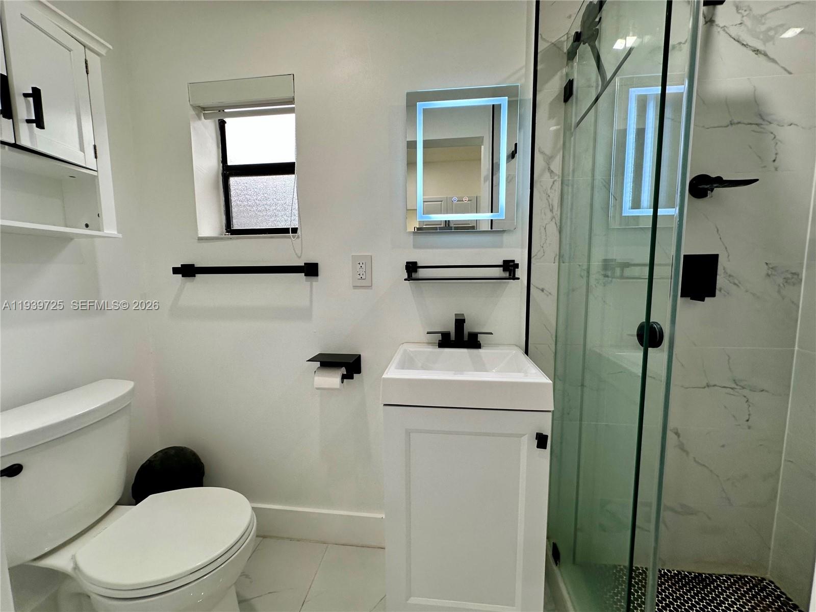1309 Northwest 55th Terrace, Unit STUDIO Miami, FL 33142 - Photo 7 of 18 a bathroom with a toilet a sink and shower