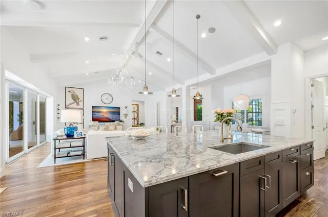 a kitchen with granite countertop a sink counter top space and living room view