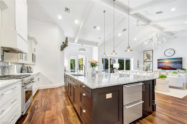 a kitchen with stainless steel appliances granite countertop a stove and a wooden floors