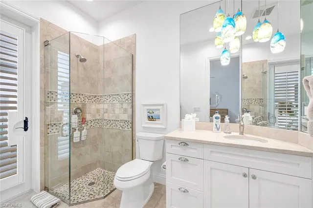 a bathroom with a granite countertop shower sink vanity mirror and toilet
