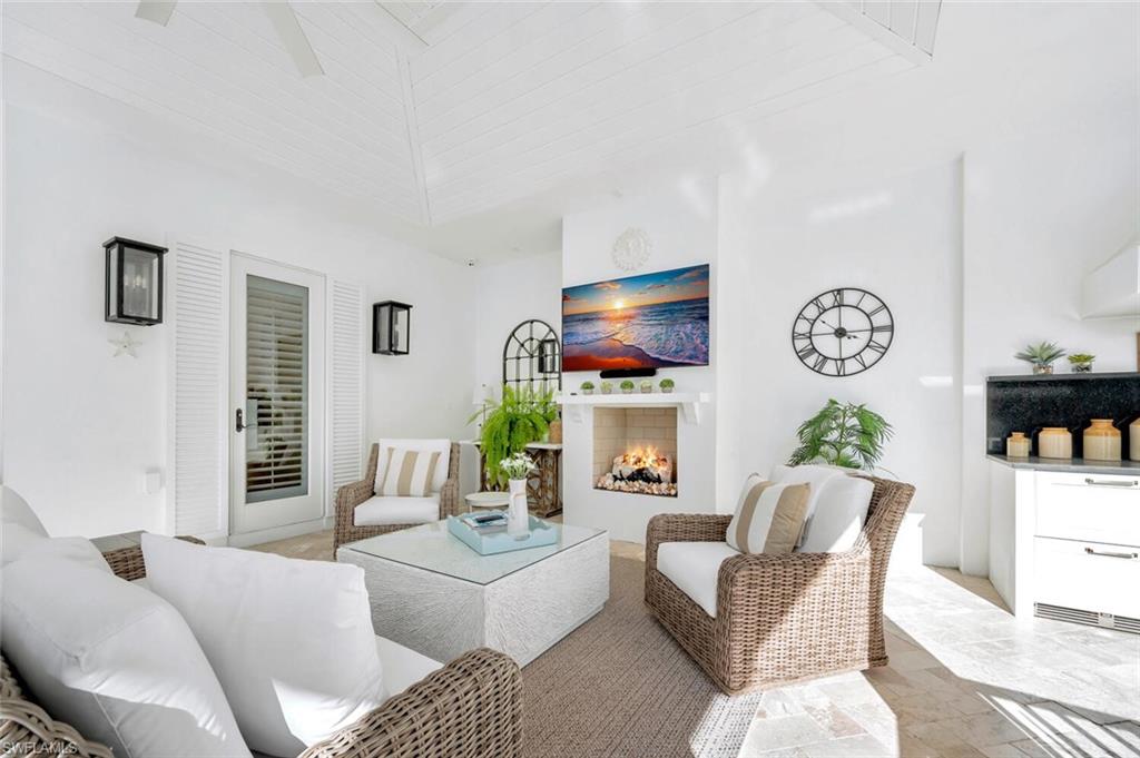 Undisclosed Address Naples, FL 34102 - Photo 35 of 44 a living room with furniture a chandelier and a flat screen tv