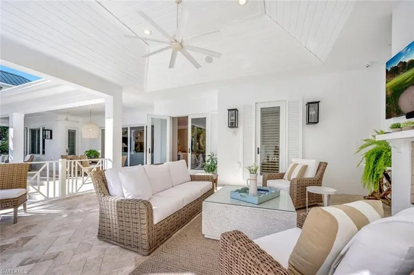 a living room with furniture a flat screen tv and a large window