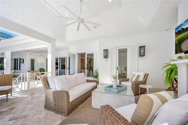 a living room with furniture a flat screen tv and a large window