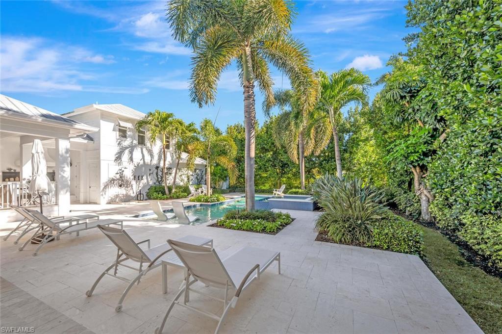 Undisclosed Address Naples, FL 34102 - Photo 40 of 44 a view of a patio with table and chairs under an umbrella