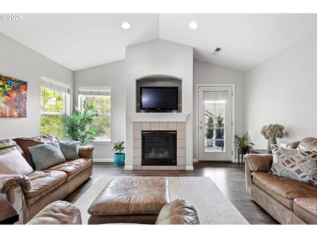 a living room with furniture a fireplace and a flat screen tv