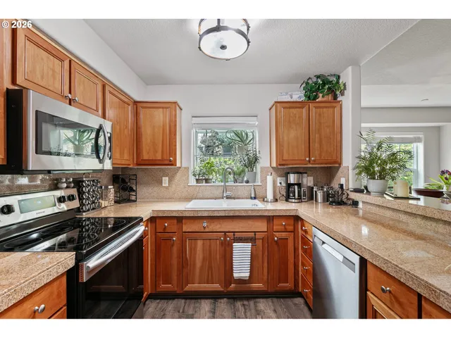 a kitchen with kitchen island granite countertop a sink a counter space appliances and cabinets