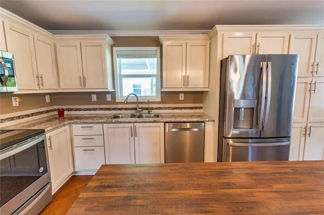 a kitchen with stainless steel appliances granite countertop a refrigerator stove and sink