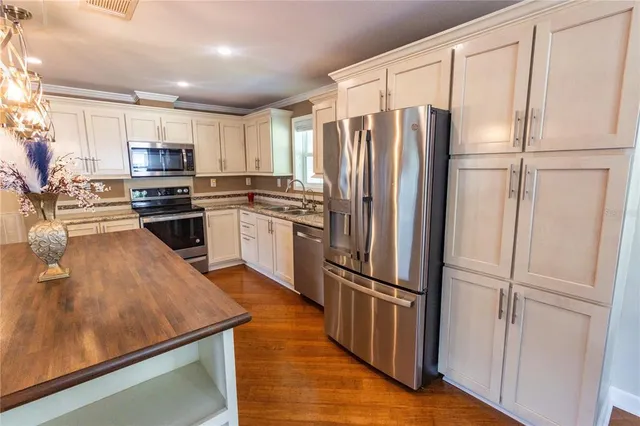 a kitchen with stainless steel appliances granite countertop a refrigerator stove and oven