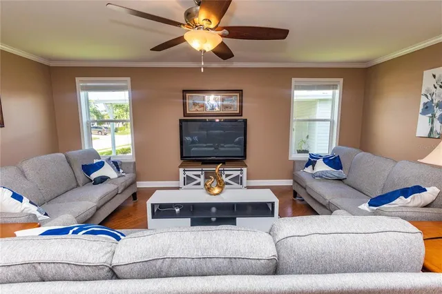 a living room with furniture a flat screen tv and a window
