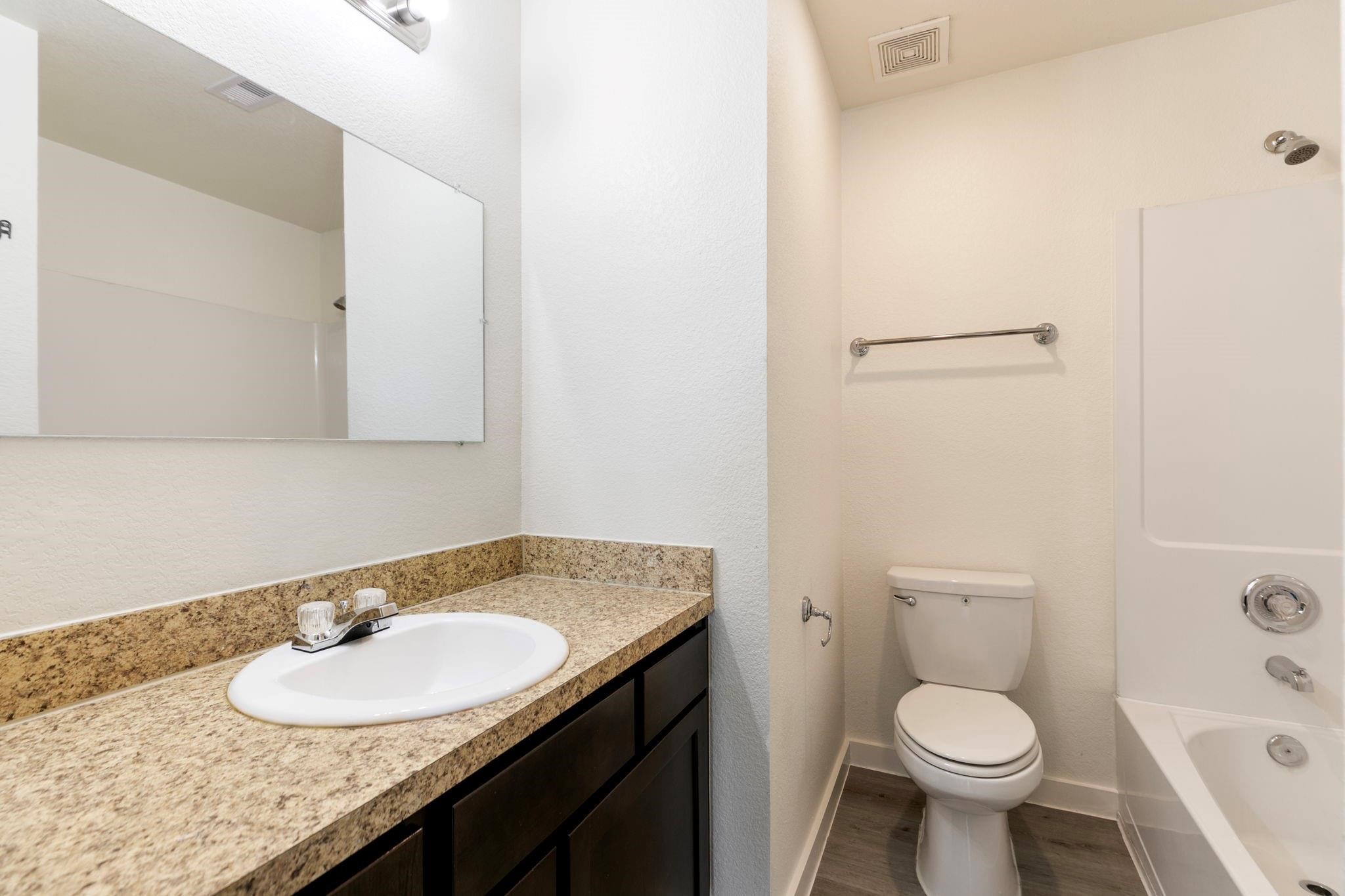 12603 Telge Road, Unit 27D Cypress, TX 77429 - Photo 13 of 27 a bathroom with a granite countertop sink toilet and a mirror