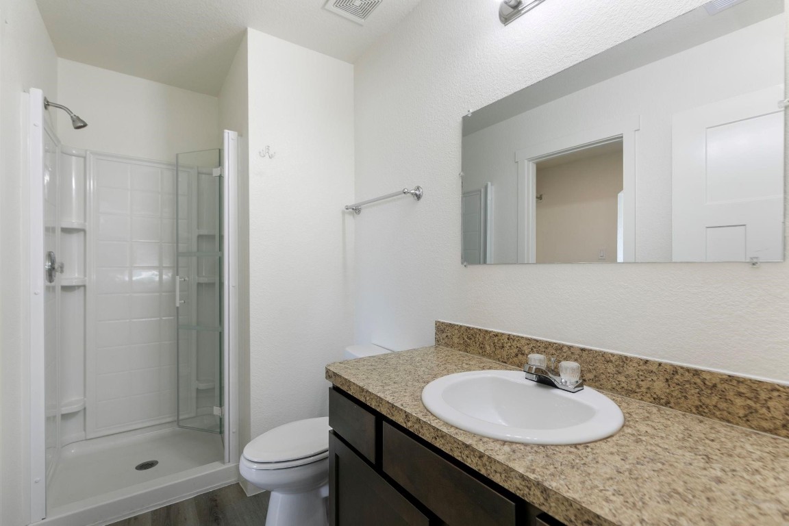 12603 Telge Road, Unit 27D Cypress, TX 77429 - Photo 20 of 27 a bathroom with a granite countertop sink toilet a mirror and shower