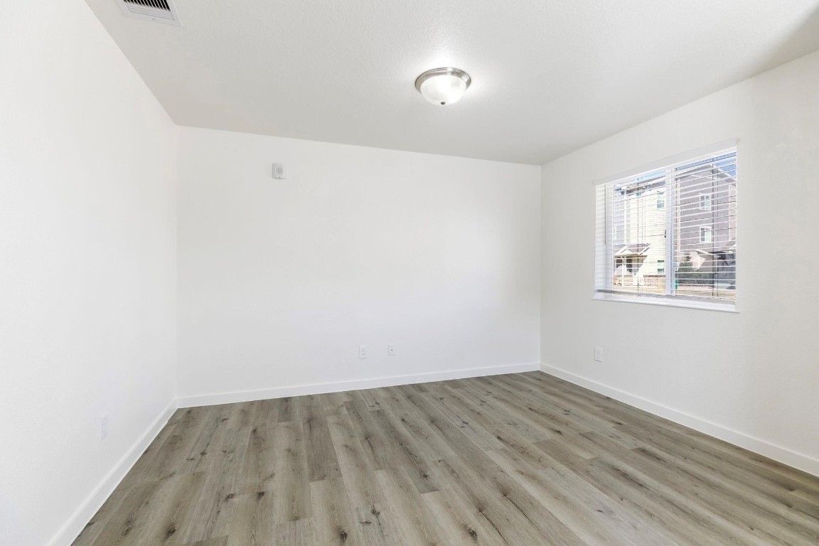 12603 Telge Road, Unit 27D Cypress, TX 77429 - Photo 6 of 27 an empty room with wooden floor and windows