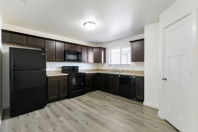 a kitchen with granite countertop cabinets stainless steel appliances and a sink