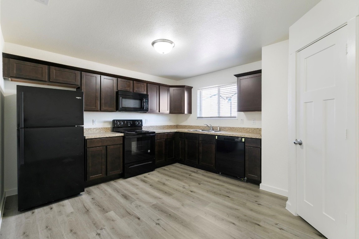 12603 Telge Road, Unit 27D Cypress, TX 77429 - Photo 8 of 27 a kitchen with a refrigerator sink and cabinets