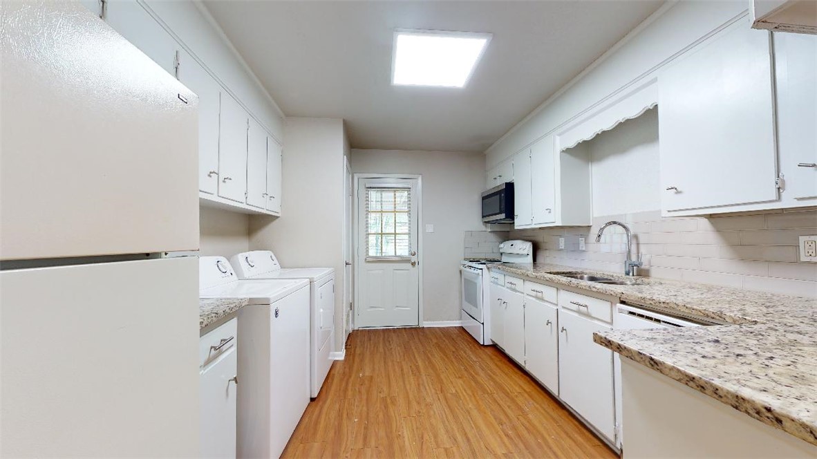 3923 Olive Street, Unit A Bryan, TX 77801 - Photo 11 of 27 a kitchen with granite countertop a sink a stove refrigerator and cabinets