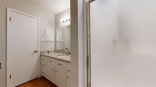 a bathroom with a granite countertop sink toilet and shower