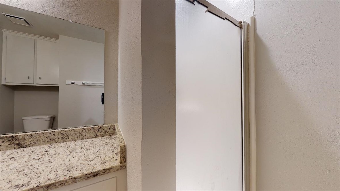 3923 Olive Street, Unit A Bryan, TX 77801 - Photo 15 of 27 a bathroom with a granite countertop sink and a mirror
