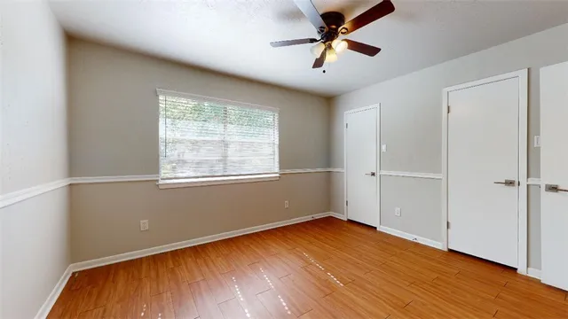 a view of empty room with wooden floor