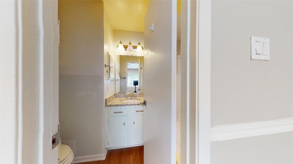 3923 Olive Street, Unit A Bryan, TX 77801 - Photo 22 of 27 a bathroom with a sink a toilet and mirror