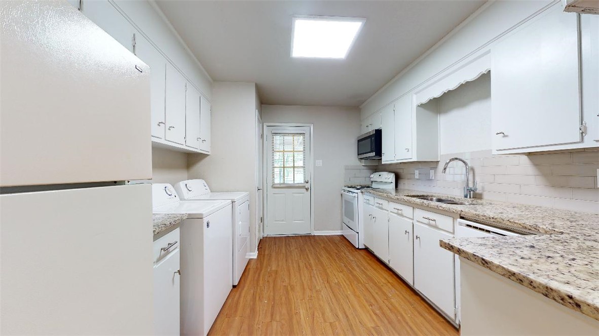 3923 Olive Street, Unit A Bryan, TX 77801 - Photo 8 of 27 a kitchen with granite countertop a sink stove and refrigerator
