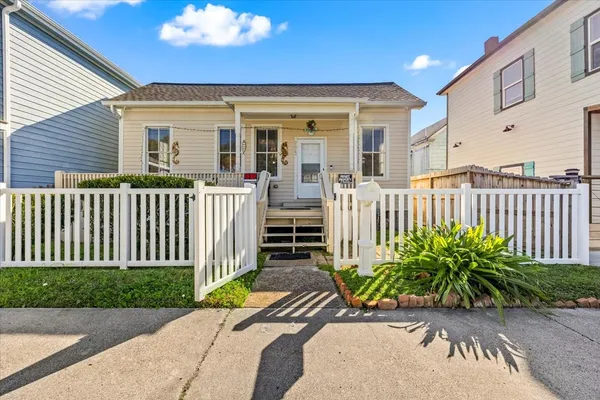 a view of a house with a small yard and wooden fence