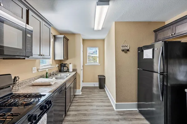a kitchen with stainless steel appliances granite countertop a refrigerator stove and sink