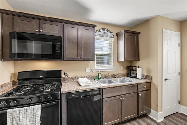 a kitchen with stainless steel appliances a stove sink microwave and cabinets