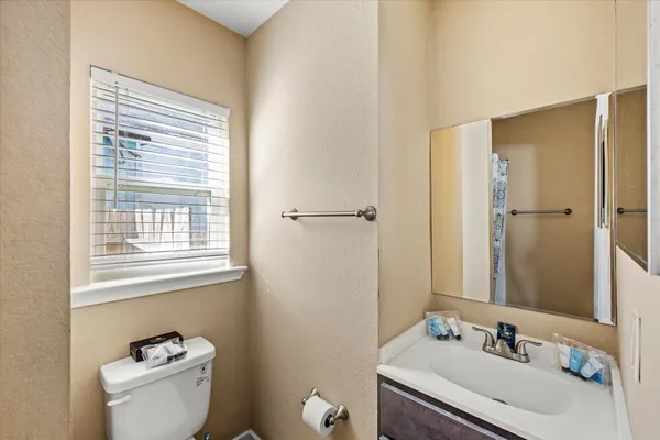 a bathroom with a sink toilet and a mirror