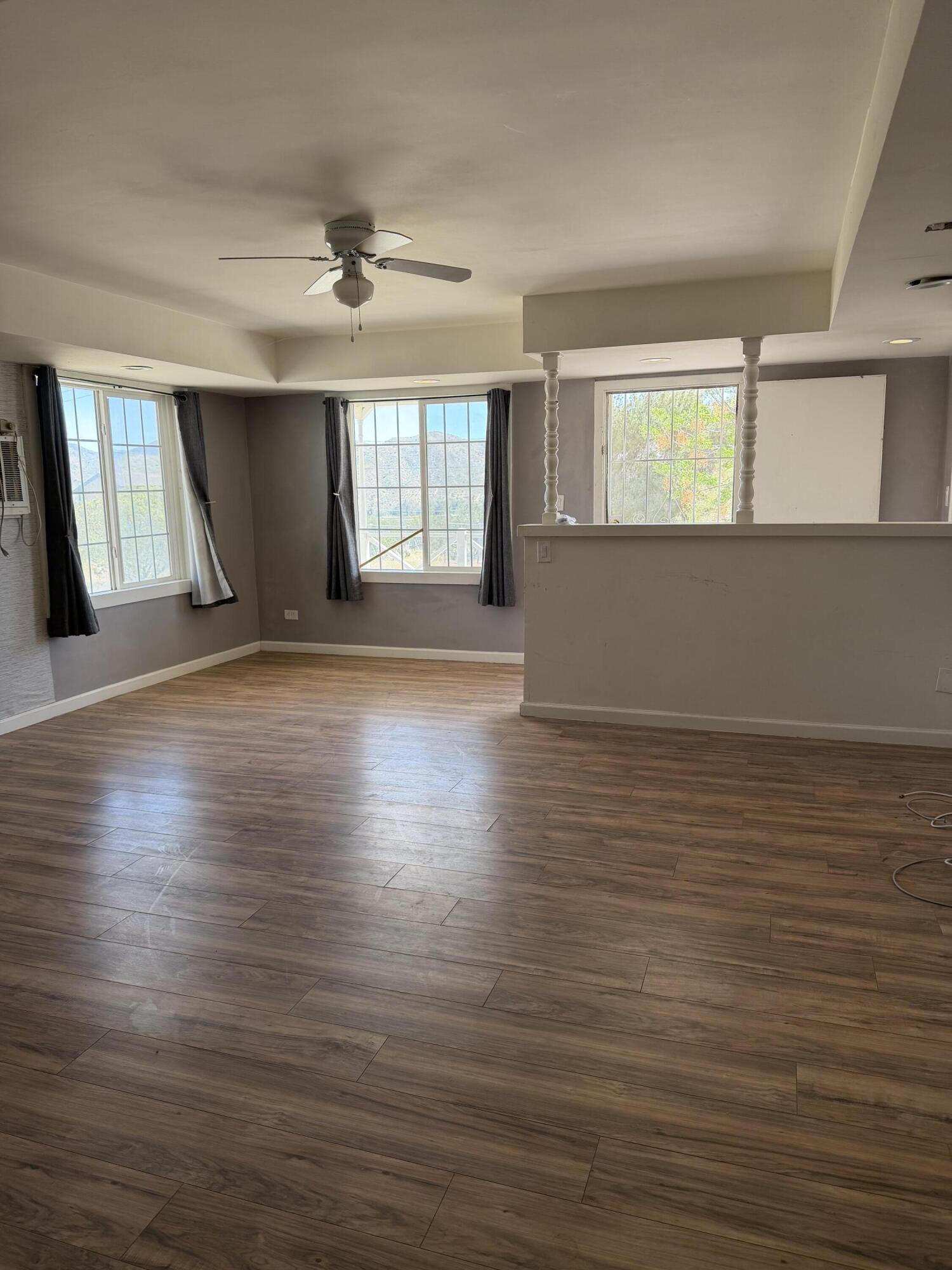50988 Canyon Road Morongo Valley, CA 92256 - Photo 15 of 68 an empty room with wooden floor and windows