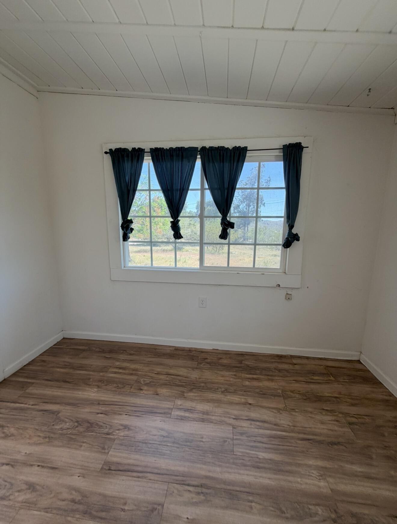 50988 Canyon Road Morongo Valley, CA 92256 - Photo 34 of 68 an empty room with wooden floor and windows